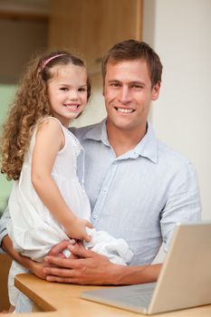 Young father showing laptop to his daughter