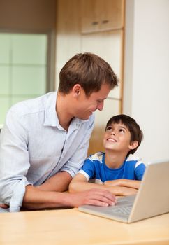 Father and son with laptop in the kitchen