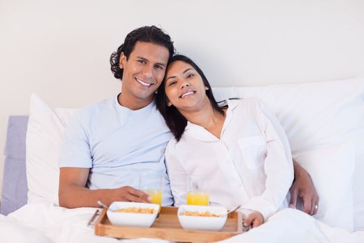 Young couple enjoying breakfast in the bed