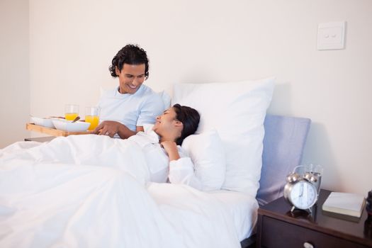 Young man brought breakfast to the bed for his girlfriend