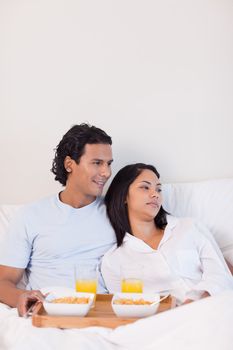 Young couple eating breakfast in the bed