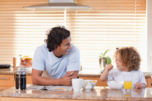Young father and daughter having breakfast in the kitchen