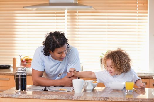 Young father and daughter having breakfast in the kitchen together