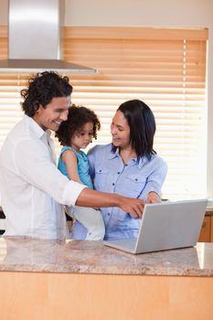 Young family using notebook in the kitchen together