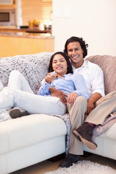 Happy young couple watching television together
