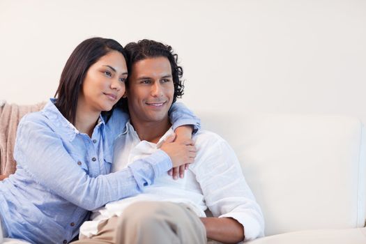 Young couple on the couch hugging