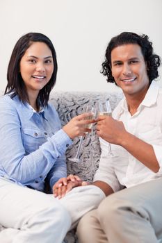 Young couple drinking sparkling wine on the couch
