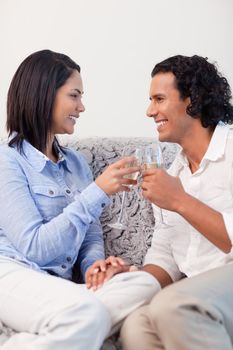 Young couple drinking sparkling wine on the sofa