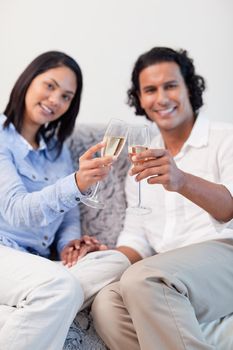 Young couple celebrating with sparkling wine in the living room