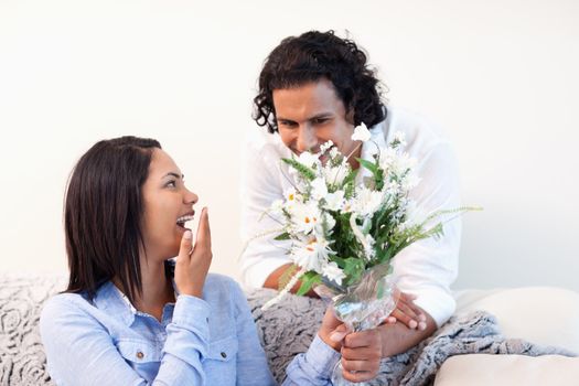 Young man giving his girlfriend a bouquet