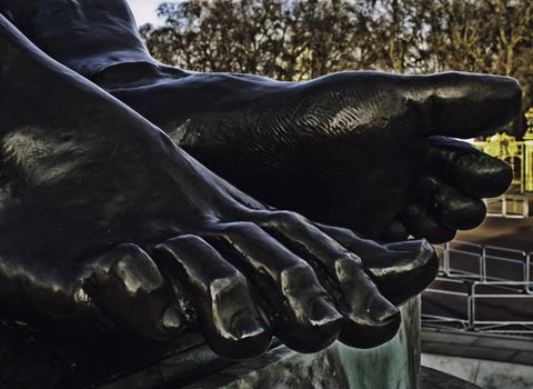 Statue detail of bare feet painted black with realistic morpholgy and anatomical detail of toes and toenails