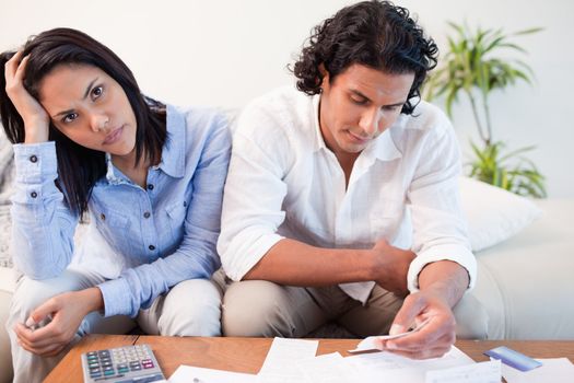 Sad young couple checking their bills