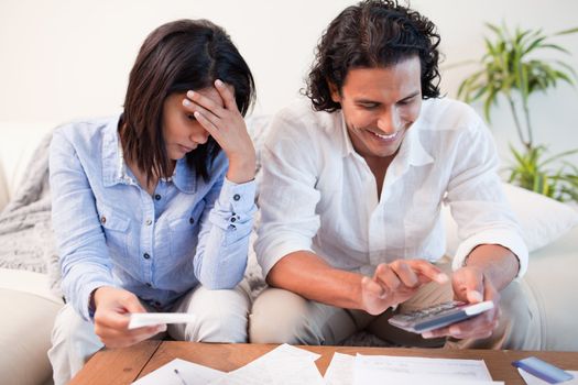Young couple checking their bills in the living room
