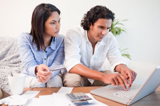 Young couple checking their bank accounts online