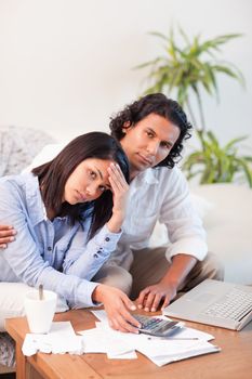 Depressed young couple checking their bills