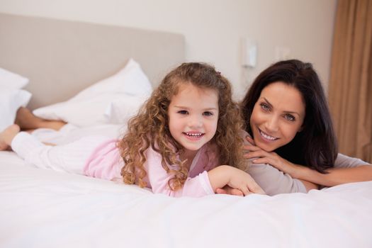 Young mother and daughter relaxing in the bedroom together