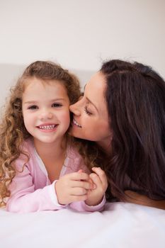 Young mother kissing her daughters cheek