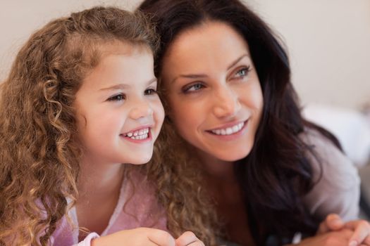 Young mother and daughter lying close together