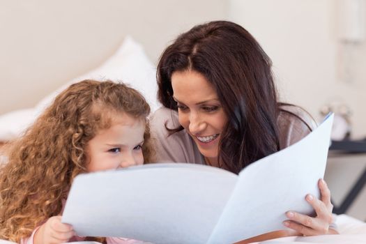 Young mother and daughter reading a book together
