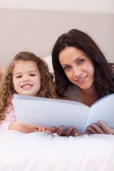 Young mother and daughter reading bedtime stories together