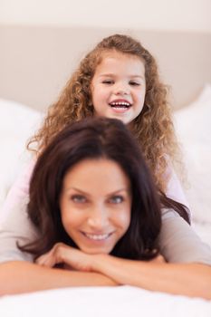 Little girl sitting on her mothers back