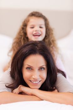 Young girl enjoys sitting on her mothers back