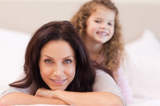 Young mother and daughter relaxing on the bed