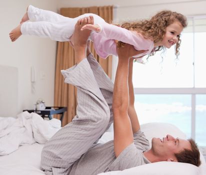 Young father playing plane with his daughter