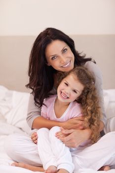 Young mother hugging her daughter