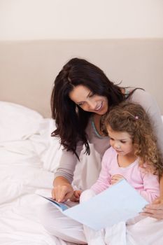 Young mother reading bedtime story for her daughter