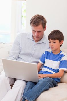 Young father and son surfing the internet together