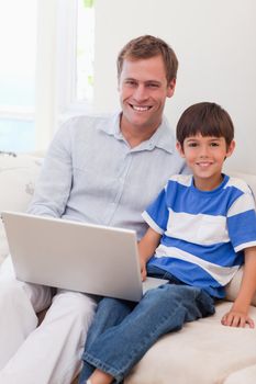 Smiling young father and son surfing the internet together