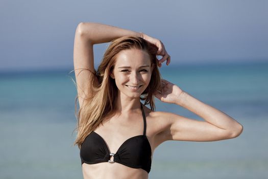 Young woman with black bikini girls laughing at the beach with blue sky in summer vacation