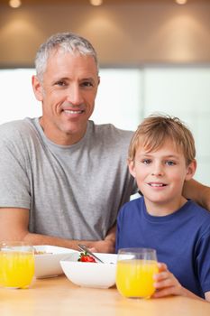 Portrait of a boy and his father having breakfast in a kitchen