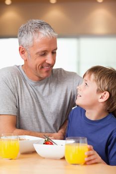 Portrait of a young boy and his father having breakfast in a kitchen