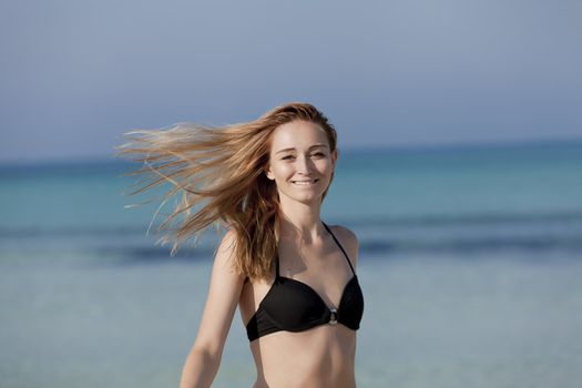 Young woman with black bikini girls laughing at the beach with blue sky in summer vacation