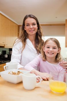 Portrait of a mother and her daughter having breakfast in a kitchen
