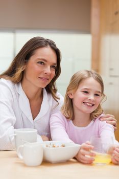 Portrait of a beautiful mother and her daughter having breakfast in a kitchen
