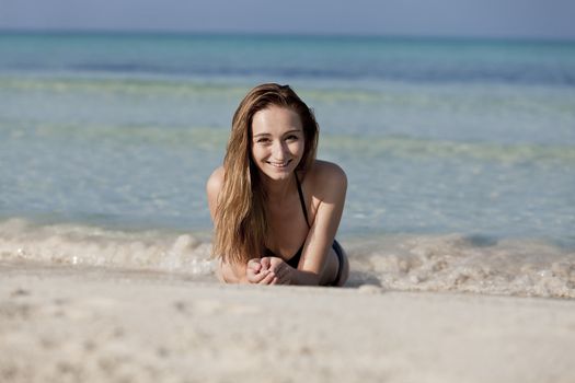 Young woman with black bikini Sexy girls on the beach in water with blue sky in summer vacation