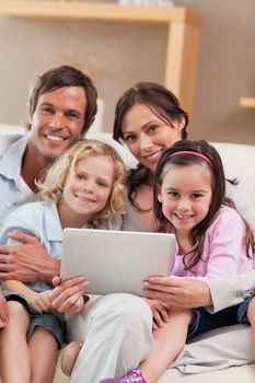 Portrait of a family using a tablet computer in a living room