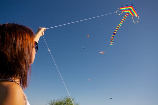 Young girl playing with colorful flying kite on sunny autumn day