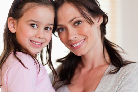 Close up of a girl and her mother smiling at the camera