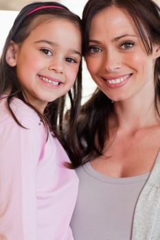 Portrait of a girl and her mother posing while smiling at the camera