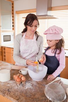 Portrait of a happy mother and her daughter baking in a kitchen