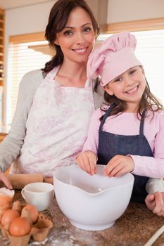 Portrait of a mother baking with her daughter in a kitchen
