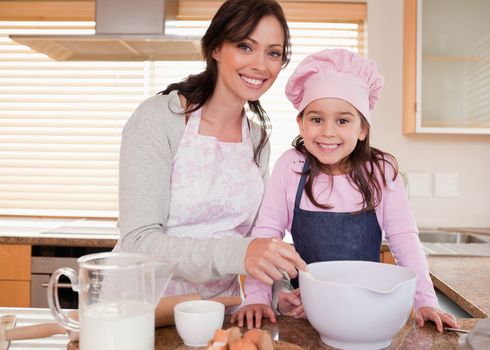 Mother baking with her daughter in a kitchen