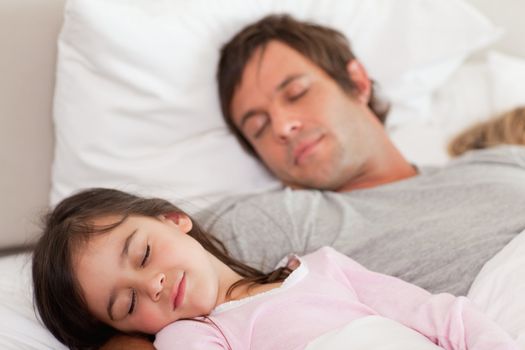 Calm father sleeping with his daughter in a bedroom