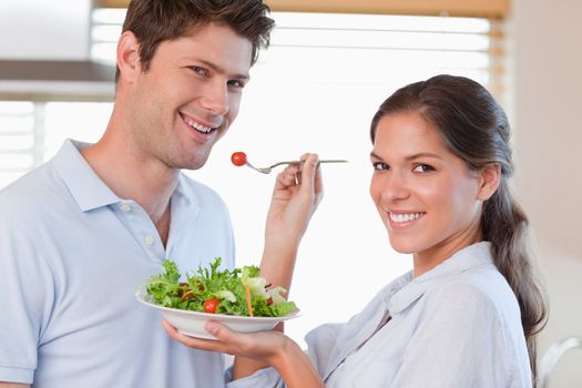 Housewife feeding her husband in their kitchen