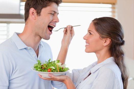 Accomplice couple tasting a salad in their kitchen