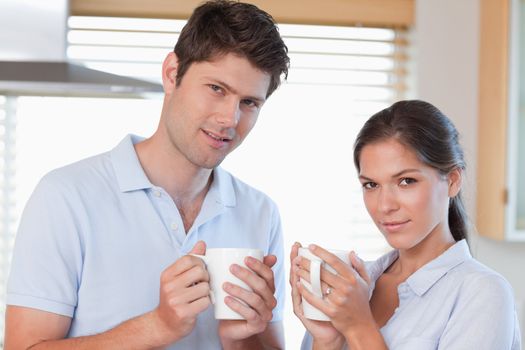Couple drinking coffee in their kitchen